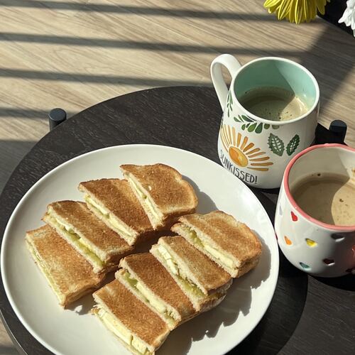 Kaya toast and a mug of coffee on a small table in the sun