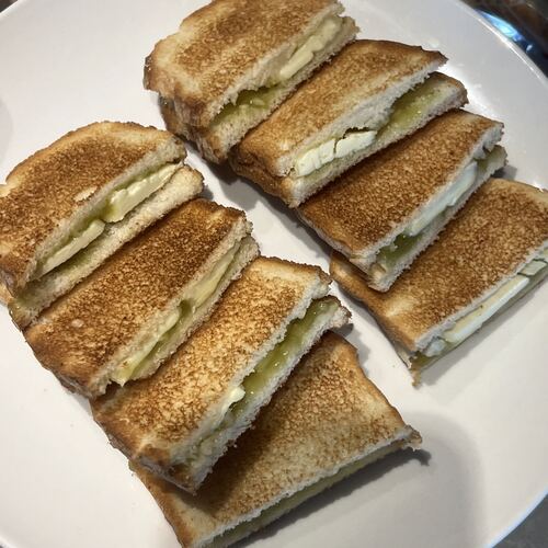 Kaya toast cut into four pieces on a white plate