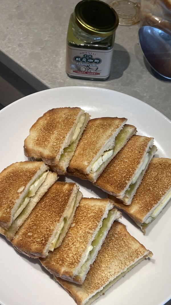 Kaya toast on a plate with a jar of kaya behind it